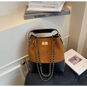 Detail of vintage suede bucket bag with metal chain strap and turn-lock closure