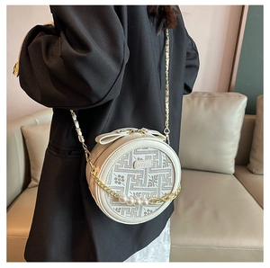Detail of white round crossbody bag with floral embroidery and pearl chain decoration