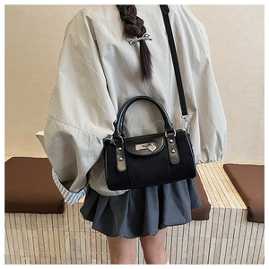 Détail du sac bandoulière noir avec breloque cadenas cœur et finitions argentées