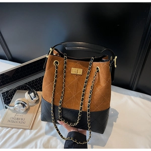 Detail of vintage suede bucket bag featuring contrast stitching and gold metal twist lock