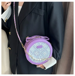 Detail of purple embroidery circular bag with pearl chain and bow decoration on model
