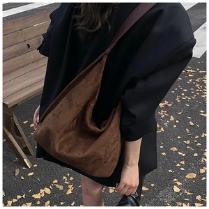 Detailed view of dark brown suede tote bag featuring reinforced double-stitched seams