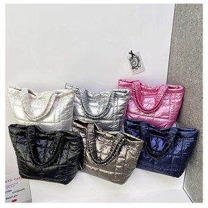 Multiple colors of quilted down tote bags showing metallic finishes and puffy texture