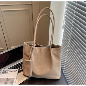 Beige tote bag with matte finish and mini coin purse next to a laptop on the desk