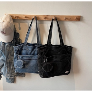 Detail of vintage denim tote bag with functional pockets and detachable round coin purse