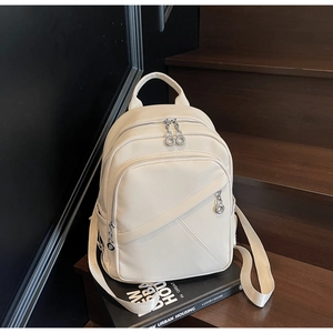 Detail of cream lychee leather backpack texture and geometric stitching on wooden stairs