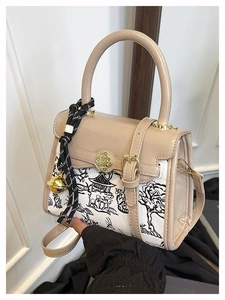 Detail of color-block mini bag showing canvas pattern and clover shaped metal clasp