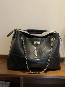 Classic black quilted suede tote bag with golden chain straps and turn-lock closure