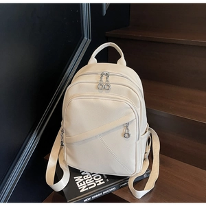 Macro detail of creamy white lychee faux leather backpack with double silver zippers
