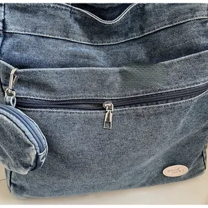 Detail of vintage blue denim tote bag featuring a small round coin purse and Good Luck label