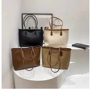 Minimalist faux leather tote bags in four colors displayed on white stairs