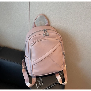Close-up of pink pebbled leather backpack with cross-stitch design and silver zippers