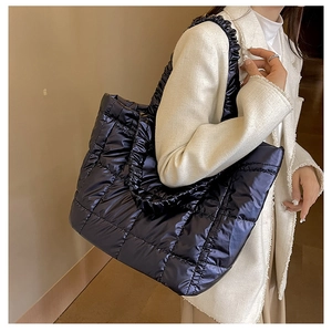 Detail of quilted tote bag with pleated shoulder straps and large capacity nylon texture