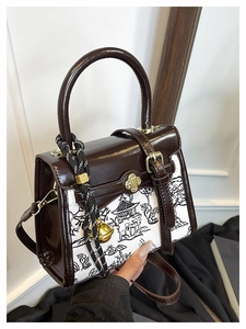 Detailed close-up of mixed-media handbag featuring landscape print and vintage buckle