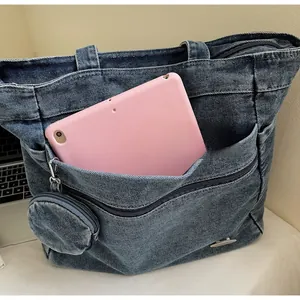 Detail view of denim tote bag showing spacious capacity and functional front zipper pocket