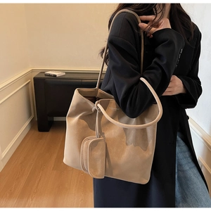 Detail of camel frosted leather tote bag with matching mini pouch and smooth texture