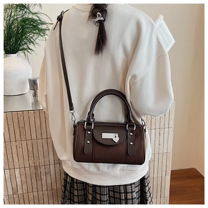 Détail du sac polochon Boston avec breloque cœur et textures en daim mélangées