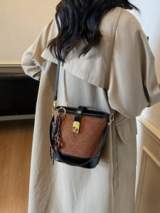 Maillard vintage brown suede bucket bag with quilted stitching and gold clasp on model