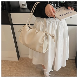 Detail der cremeweißen Falten-Handtasche mit dekorativem Knoten und Silberbeschlag