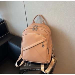 Detailed close-up of apricot lychee-textured leather backpack with silver metal zippers