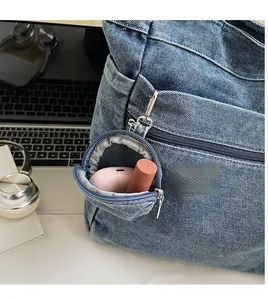Mini denim bag detail showing functional metal clip and space for earphones and lipstick