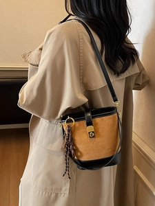 Vintage brown and black quilted bucket bag with gold lock and bear charm on model