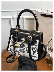 Detailed shot of the ink landscape canvas bag with black leather trim and golden floral clasp