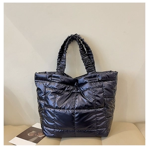Macro shot of dark navy padded tote bag featuring square quilting and ruched handles