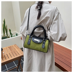 Vue arrière d'un sac seau rétro en velours vert et cuir noir porté par un mannequin