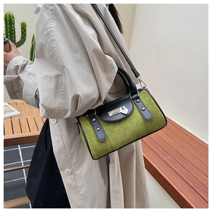 Vue détaillée du sac bandoulière en daim vert avec pendentif cœur et rivets argentés