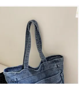 Close-up of durable denim tote bag handles and zipper closure with washed texture