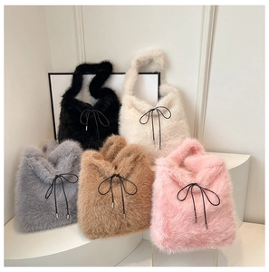 Vue détaillée de cinq sacs cabas en peluche avec nœuds noirs sur des supports blancs