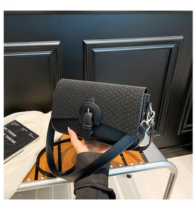 Detail of crossbody bag featuring black woven straw texture and smooth leather finish