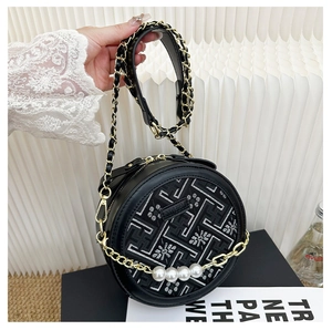 Macro shot of circular crossbody bag with floral embroidery and large pearl accents