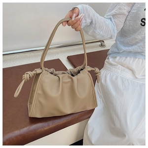 Detail der khakifarbenen Cloud-Bag mit weicher Lederstruktur und stilvollem Knotengriff
