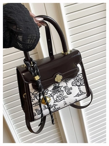 Detail of vintage crossbody bag showing contrast panels and gold clover metal clasp