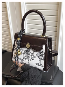 Detail of color-block handbag with Chinese ink painting, leather handle and gold floral clasp