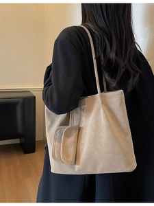 Retro beige tote bag with a small pouch on model in a minimalist indoor setting