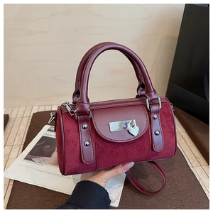 Détail du sac seau bordeaux en mélange cuir-suède avec pendentif en forme de cœur