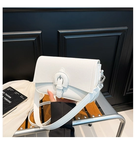 Detail of white saddle bag with wide strap, matte faux leather and silver hardware