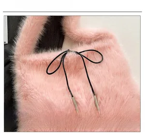 Gros plan sur un sac cabas en fausse fourrure rose avec nœud noir et embouts argentés