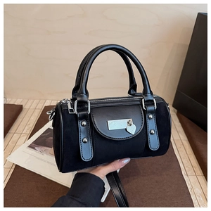 Vue détaillée du sac Boston noir avec rivets argentés et pendentif en forme de cœur