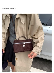 Outdoor street style shot of brown suede crossbody handbag with silver zipper detail