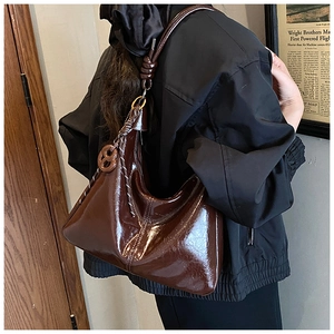 Detail of dark brown glossy leather Hobo bag featuring a unique knotted shoulder strap