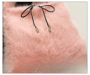 Détail de la texture en fausse fourrure rose avec cordon noir et embouts argentés