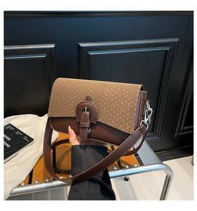 Detail of the vintage brown shoulder bag showing woven texture and leather strap buckle