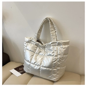 Detail of champagne silver quilted tote bag with metallic finish and ruched handle design
