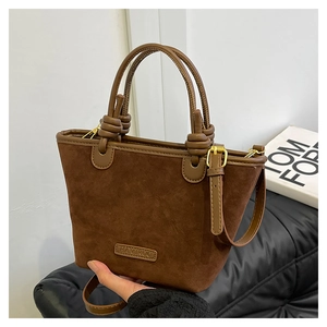 Dettaglio della borsa tote in pelle scamosciata marrone con profili in pelle e nodo decorativo