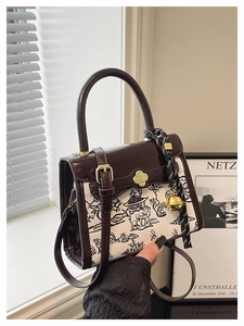 Detailed shot of retro patchwork handbag with landscape print and clover twist lock