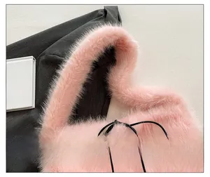 Détail d'un sac bandoulière en fausse fourrure rose avec sangle épaisse en peluche